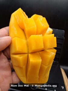Nam Doc Mai mango cut into cubes showing deep orange smooth flesh - Nam Doc Mai mango